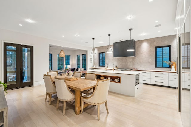 dining space featuring french doors and light hardwood / wood-style floors