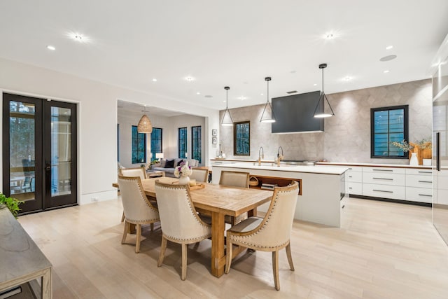 dining room featuring french doors and light hardwood / wood-style flooring