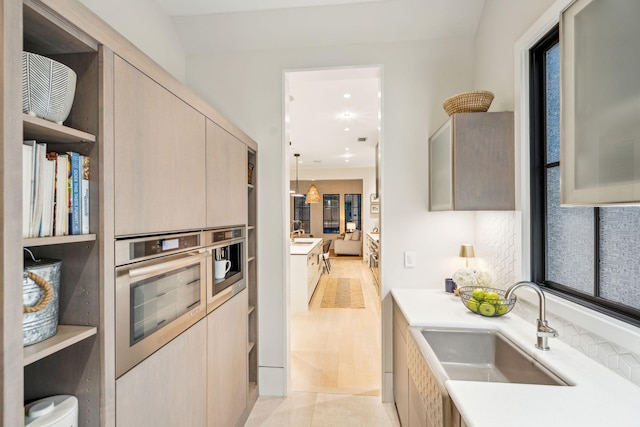 kitchen with sink, hanging light fixtures, and light brown cabinetry