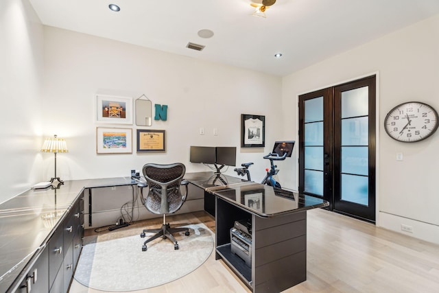 office with french doors and light hardwood / wood-style floors