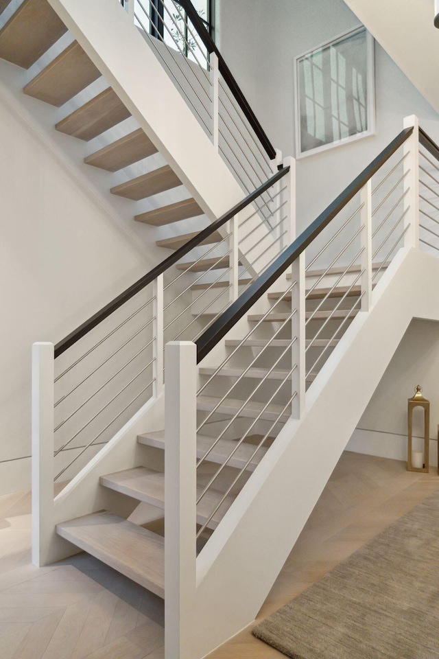 stairway with a high ceiling and parquet floors