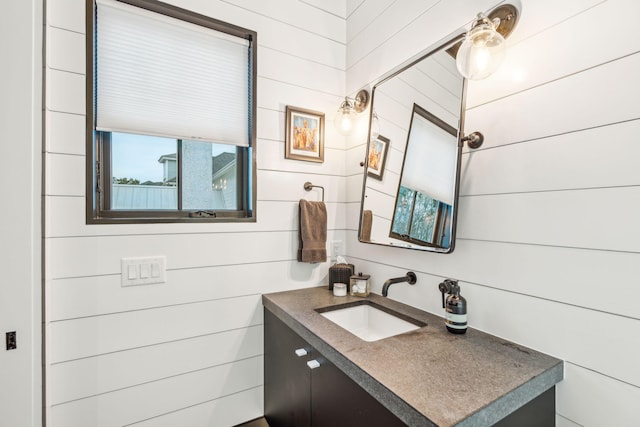 bathroom with wood walls and vanity