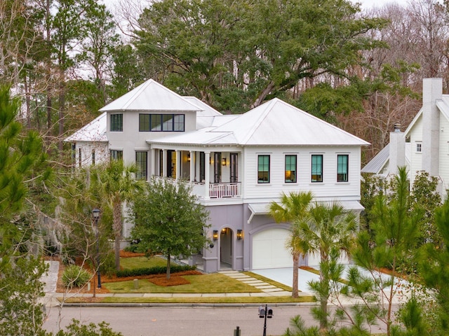 modern farmhouse featuring a balcony, a front yard, and a garage