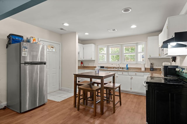 2170 Midland Park Rd, North Charleston, SC 29406 - kitchen featuring freestanding refrigerator, electric range, under cabinet range hood, white cabinetry, and recessed lighting
