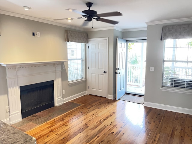 unfurnished living room featuring dark hardwood / wood-style flooring, crown molding, and ceiling fan