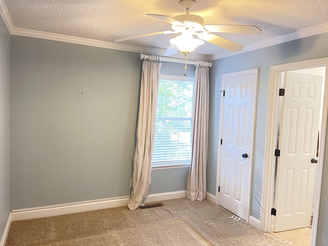 interior space featuring multiple windows, light colored carpet, a textured ceiling, and ceiling fan