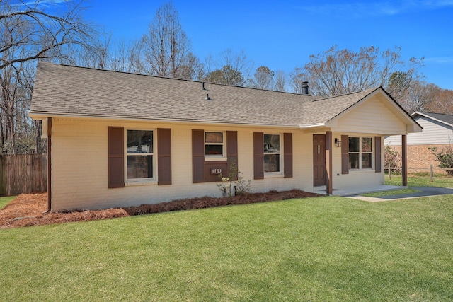 ranch-style home featuring a shingled roof, fence, and brick siding