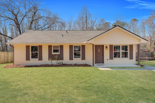 ranch-style home featuring a shingled roof, fence, a front lawn, and brick siding