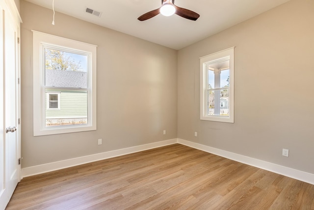 unfurnished room with ceiling fan, light wood-style flooring, visible vents, and baseboards