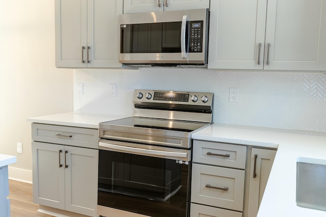 kitchen featuring backsplash, stainless steel appliances, and light countertops