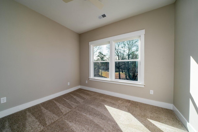 empty room with visible vents, carpet flooring, lofted ceiling, and baseboards