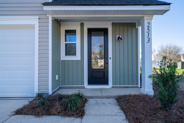 doorway to property featuring a garage and roof with shingles