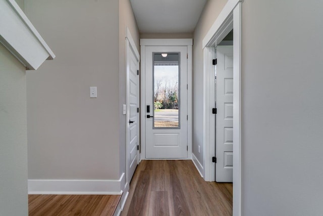 doorway to outside with baseboards and wood finished floors