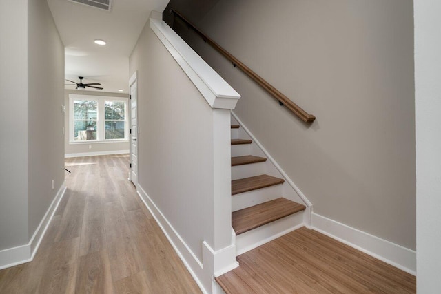 staircase with a ceiling fan, recessed lighting, wood finished floors, and baseboards