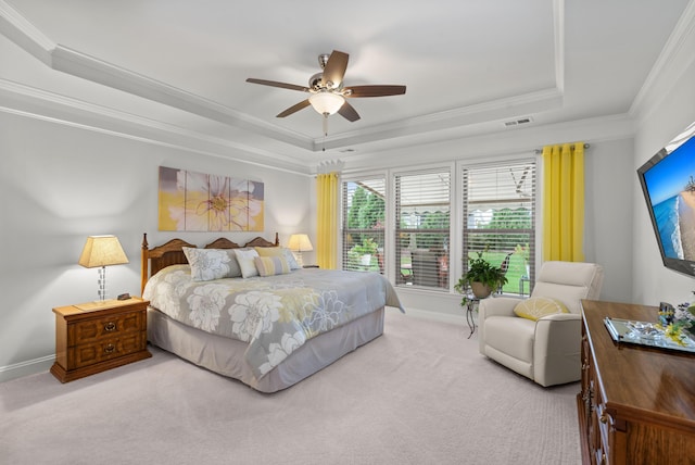 bedroom with a ceiling fan, visible vents, crown molding, a tray ceiling, and carpet flooring