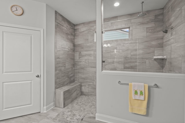 bathroom with baseboards and a tile shower
