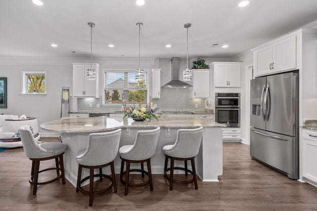 kitchen with wall chimney exhaust hood, white cabinets, a wealth of natural light, and stainless steel appliances