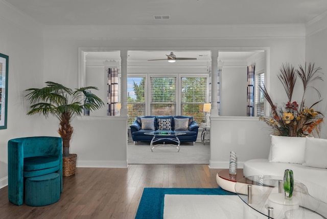 interior space featuring wood-type flooring, ornamental molding, visible vents, decorative columns, and baseboards