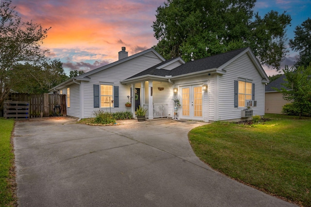 view of front of property featuring cooling unit, central air condition unit, and a lawn