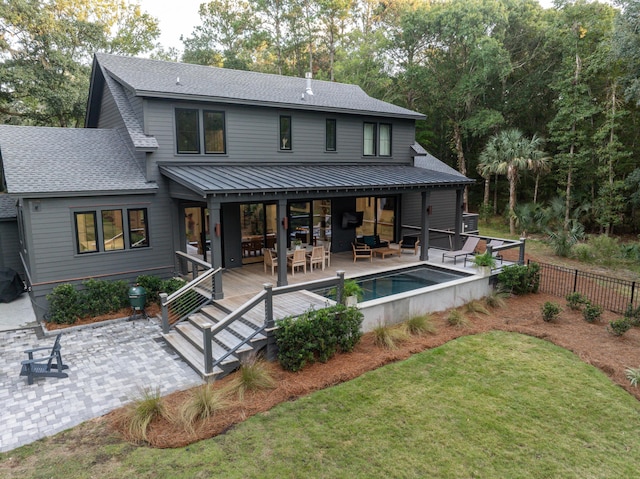 rear view of house with outdoor lounge area, a patio area, a yard, and a swimming pool side deck