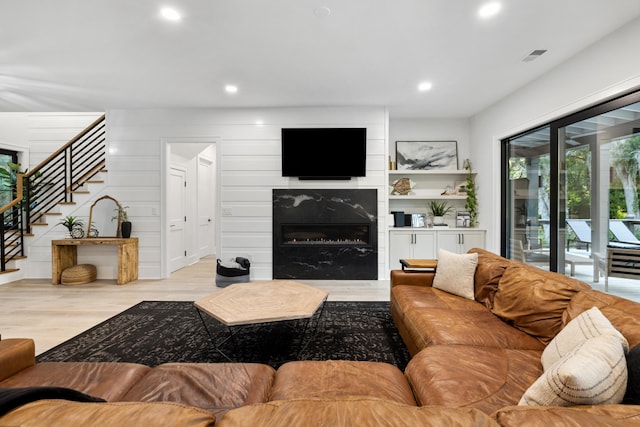 living room with a large fireplace and light hardwood / wood-style floors