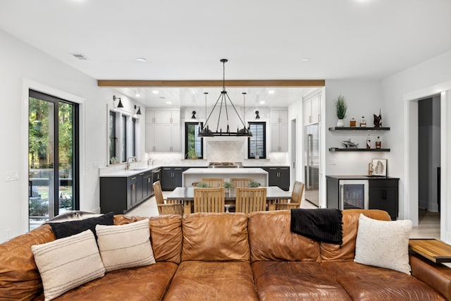 living room featuring an inviting chandelier, sink, and wine cooler