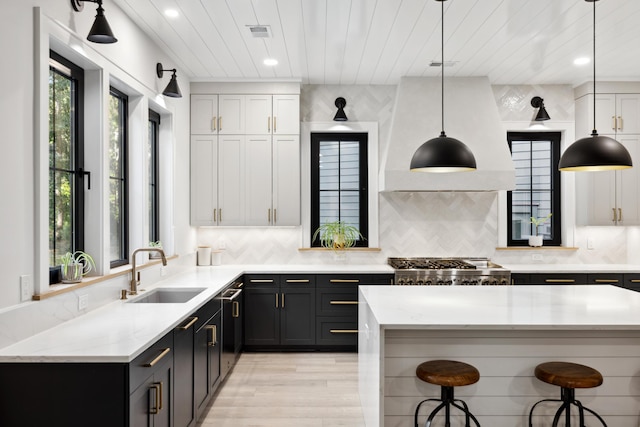 kitchen with backsplash, hanging light fixtures, sink, and a breakfast bar