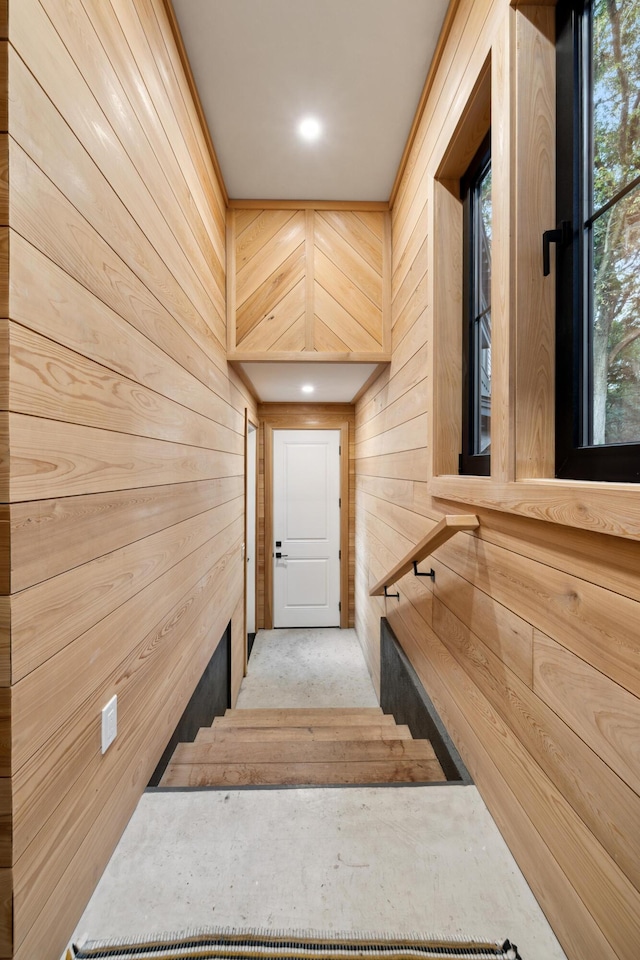 stairs featuring wood walls