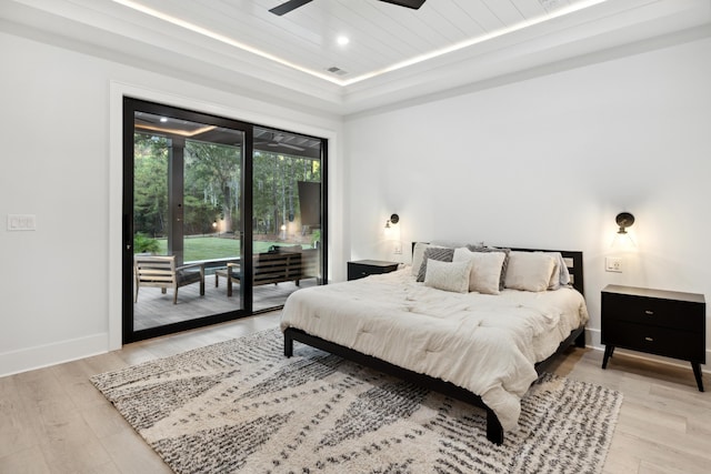 bedroom featuring light wood-type flooring, a raised ceiling, access to exterior, wooden ceiling, and ceiling fan