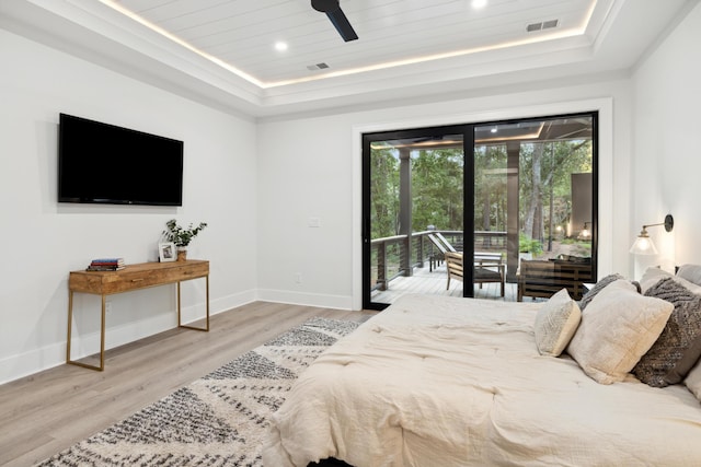 bedroom featuring light hardwood / wood-style floors, ceiling fan, a tray ceiling, wood ceiling, and access to outside