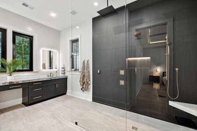 bathroom with a shower, vanity, and tile walls