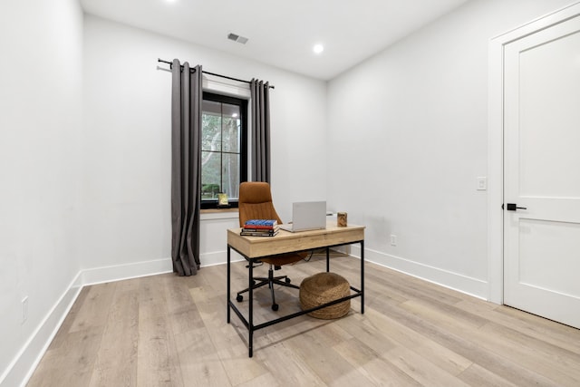 home office with light hardwood / wood-style floors