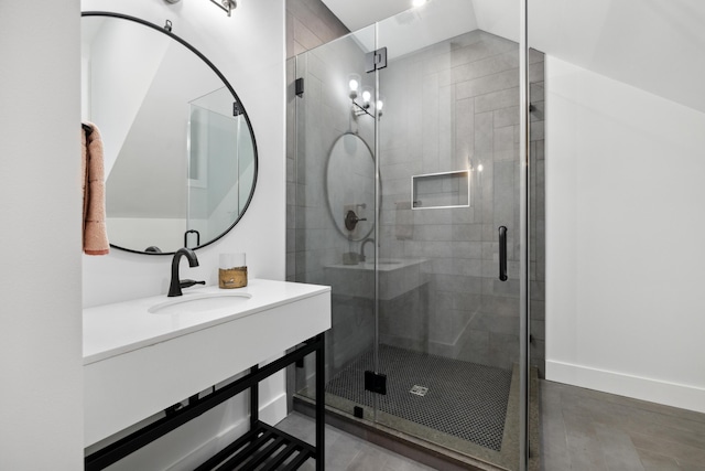 bathroom with a shower with shower door, vanity, and lofted ceiling