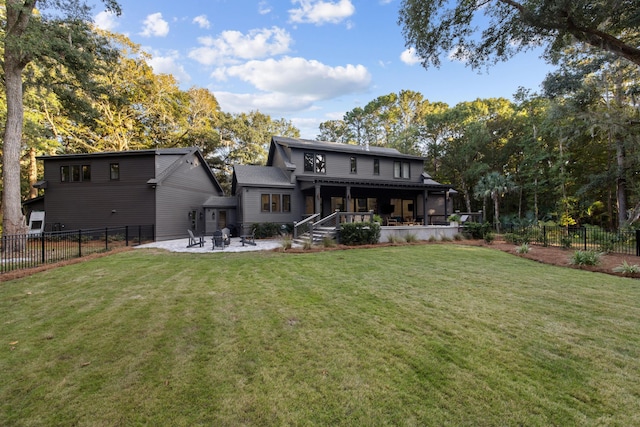 rear view of property featuring a yard and a patio area