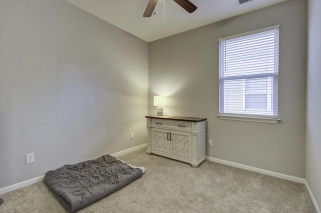 living area with light carpet and ceiling fan