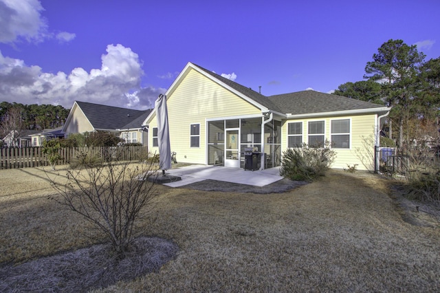 back of property with a sunroom and a patio