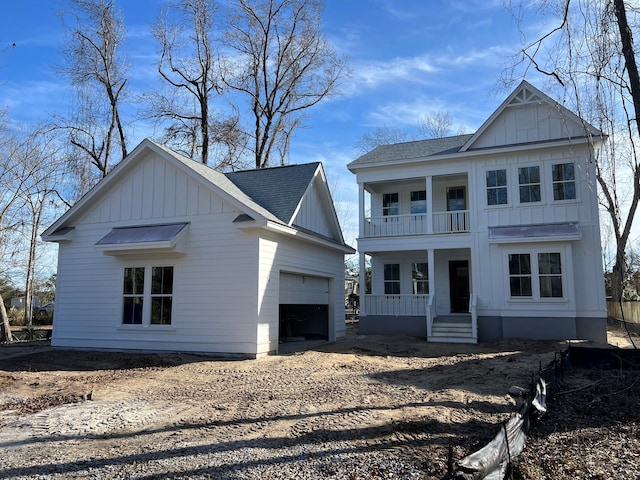 view of front of home featuring a garage, a balcony, and covered porch