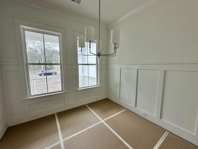 unfurnished dining area featuring light tile patterned flooring, a decorative wall, and visible vents