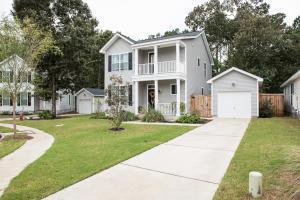 view of front of property featuring a balcony, an outdoor structure, a garage, driveway, and a porch