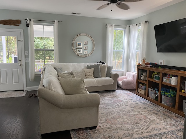 living area featuring ceiling fan, dark wood-style flooring, and baseboards