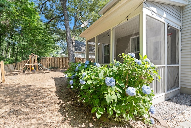 1199 Landau Ln, Mount Pleasant, SC 29466 - view of side of property featuring a sunroom, a fenced backyard, and a playground