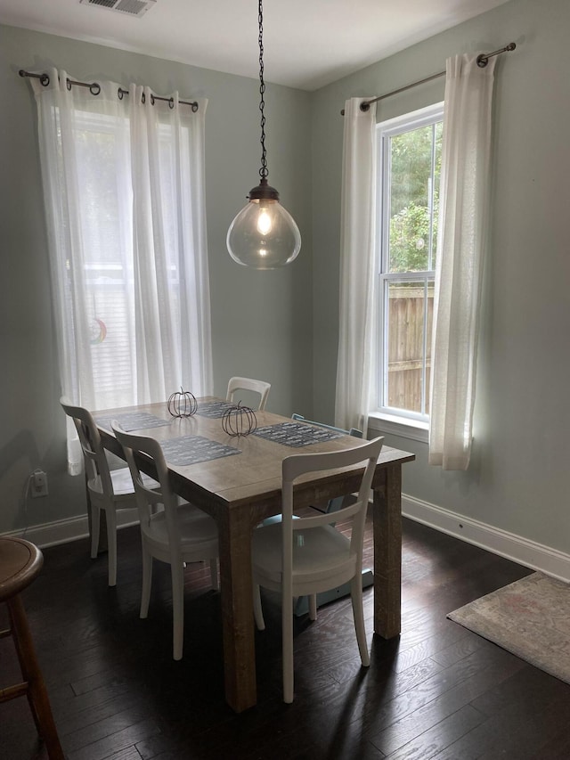 dining area with dark wood-type flooring and baseboards