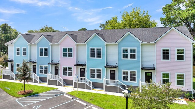 townhome / multi-family property featuring a front lawn