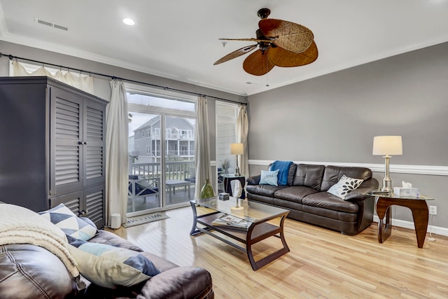 living room with light hardwood / wood-style floors, ceiling fan, and crown molding