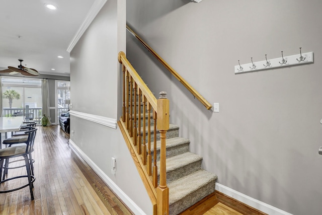 staircase featuring hardwood / wood-style floors and crown molding