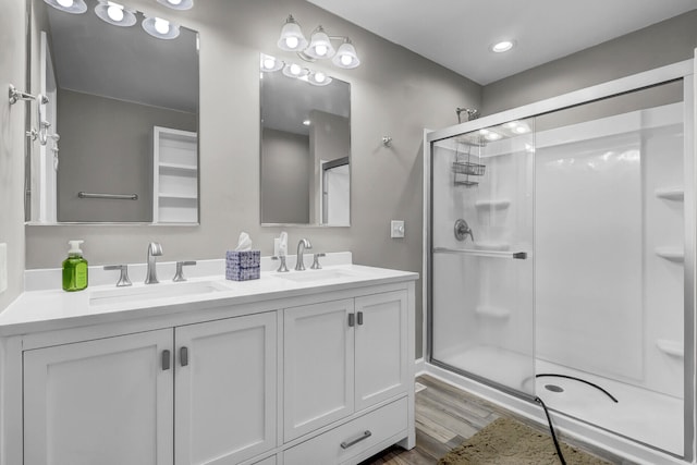 bathroom with vanity, hardwood / wood-style flooring, and a shower with door