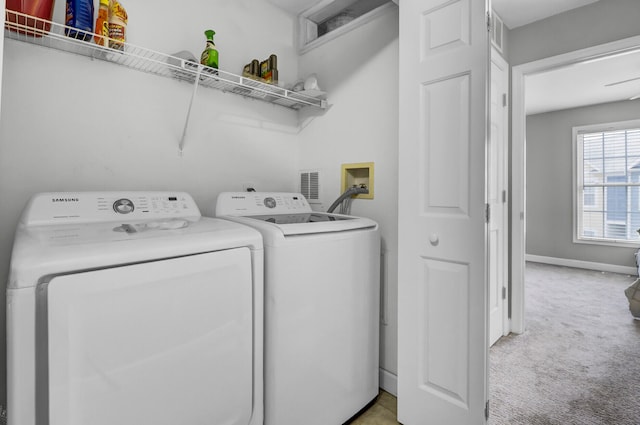 clothes washing area with light carpet and independent washer and dryer