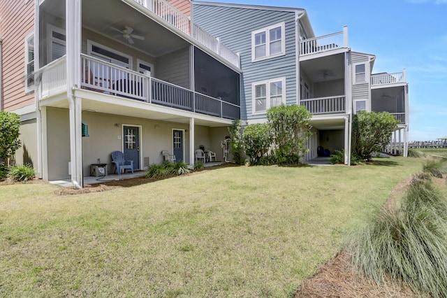 rear view of property featuring a lawn, a sunroom, ceiling fan, and a patio