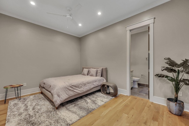 bedroom with hardwood / wood-style floors, connected bathroom, and ceiling fan