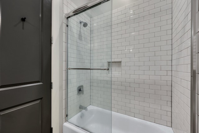 bathroom featuring bath / shower combo with glass door